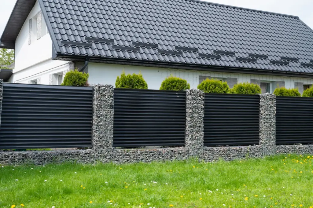 Jägerzaun aus gekreuzten Halbrundlatten an einer Grundstücksgrenze